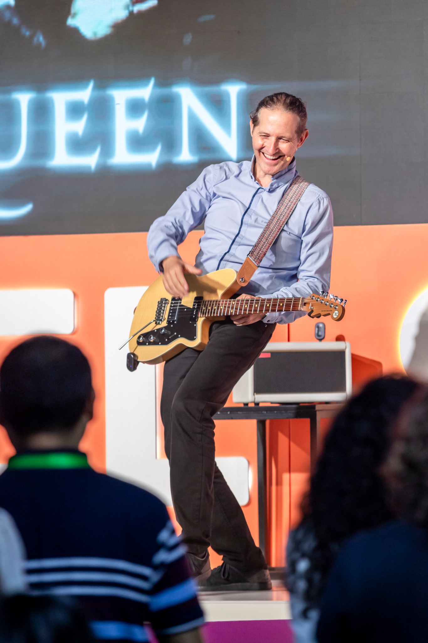 SalvaROCK smiling while playing electric guitar during a corporate keynote