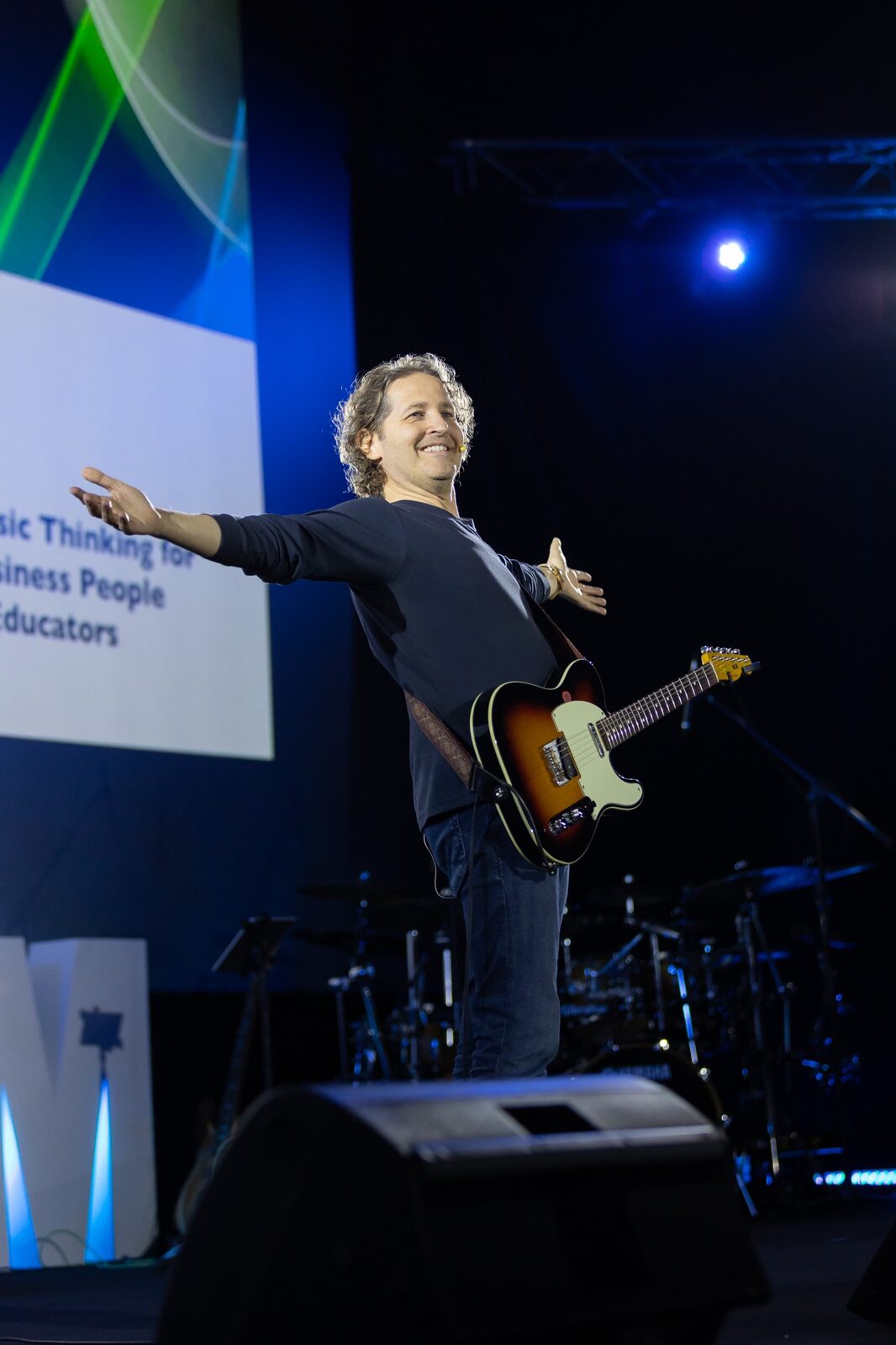 SalvaROCK smiling on stage with his guitar and arms open